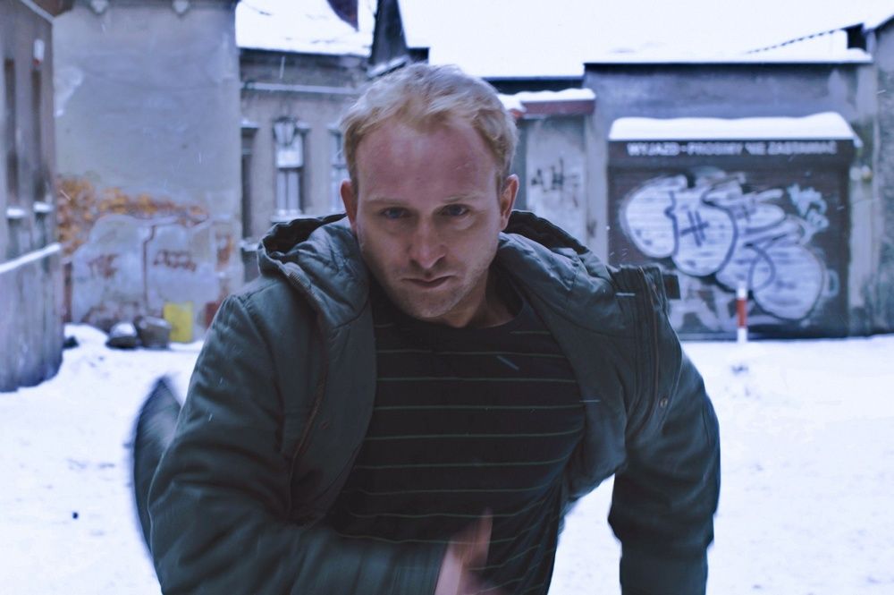 Kard z filmu Kret - Borys Szyc na tle uliczki Schodowej Kard z filmu Kret - Borys Szyc na tle uliczki Schodowej